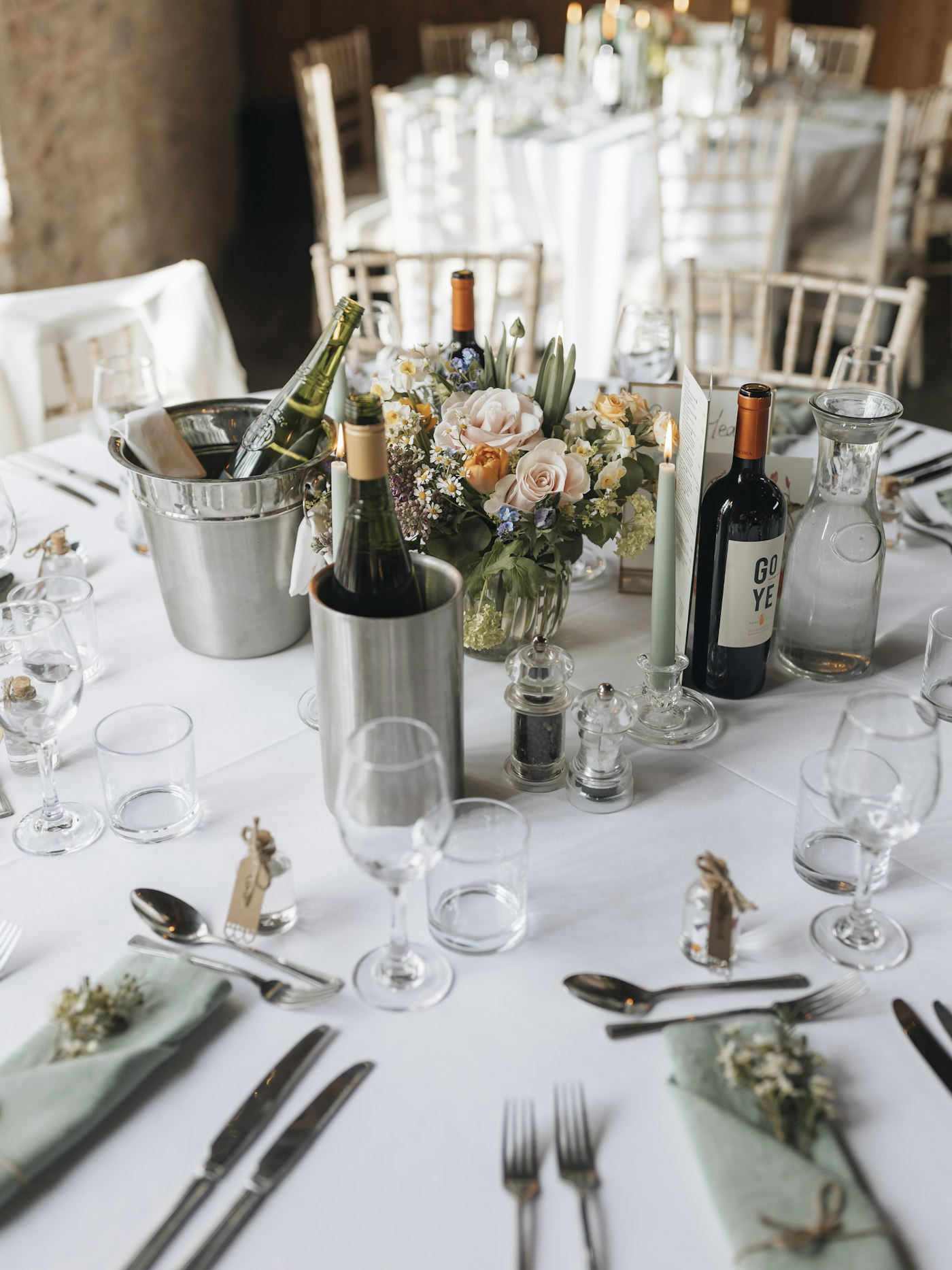 Flowers, candles and glassware arranged on a wedding reception table